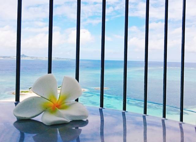 沖縄リゾートホテルのテラスから海を眺める