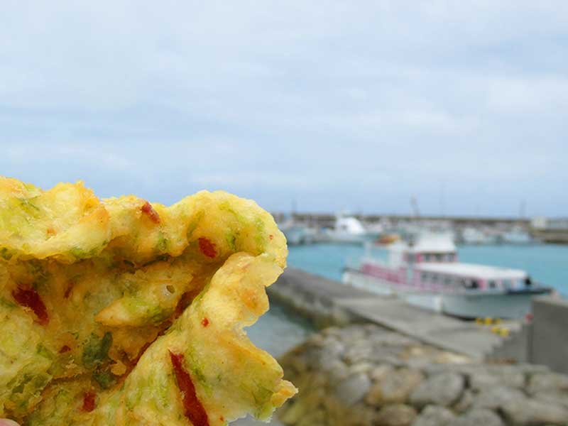 沖縄本島　奥武島の天ぷらを海辺で食べる画像